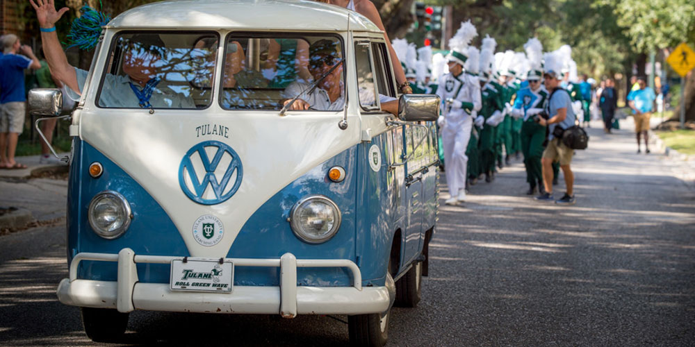 Old Volkswagen pickup truck with Tulane license plates leading the Tulane marching band.