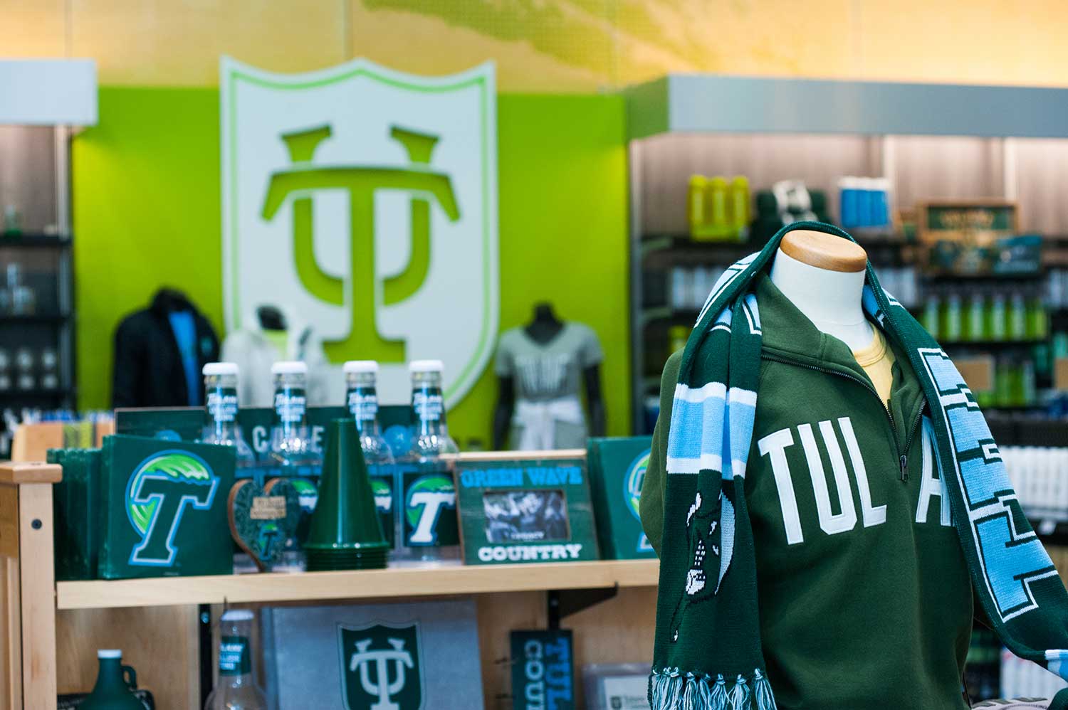 Tulane University merchandise store with green apparel, scarves, and mugs.
