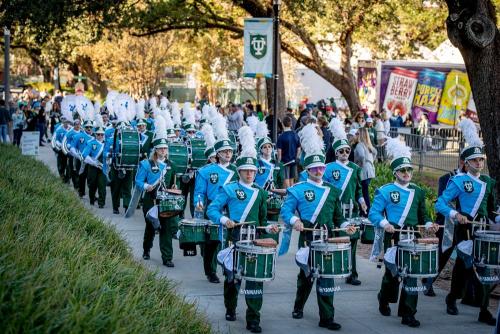 The Green Wave marching Band performing on campus.